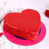 Heart-shaped red velvet cake with vanilla filling on a pink base, ideal for romantic celebrations and same day delivery gifting.