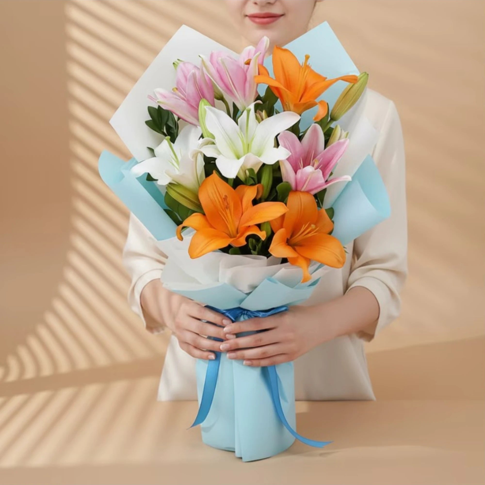 Woman holding a colorful bouquet of lilies wrapped in blue paper for celebration