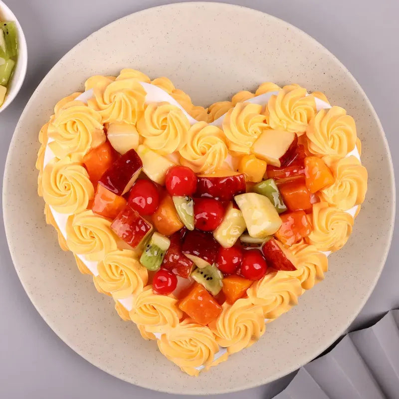 Top view of Delectable Valentine Heart Cake with vibrant fruit toppings and yellow cream swirls, ideal for gifting on Valentine's Day.