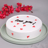 Valentine's Day Love You Pineapple Round Cake featuring red heart accents and chocolate script on white icing, perfect for romantic celebrations.