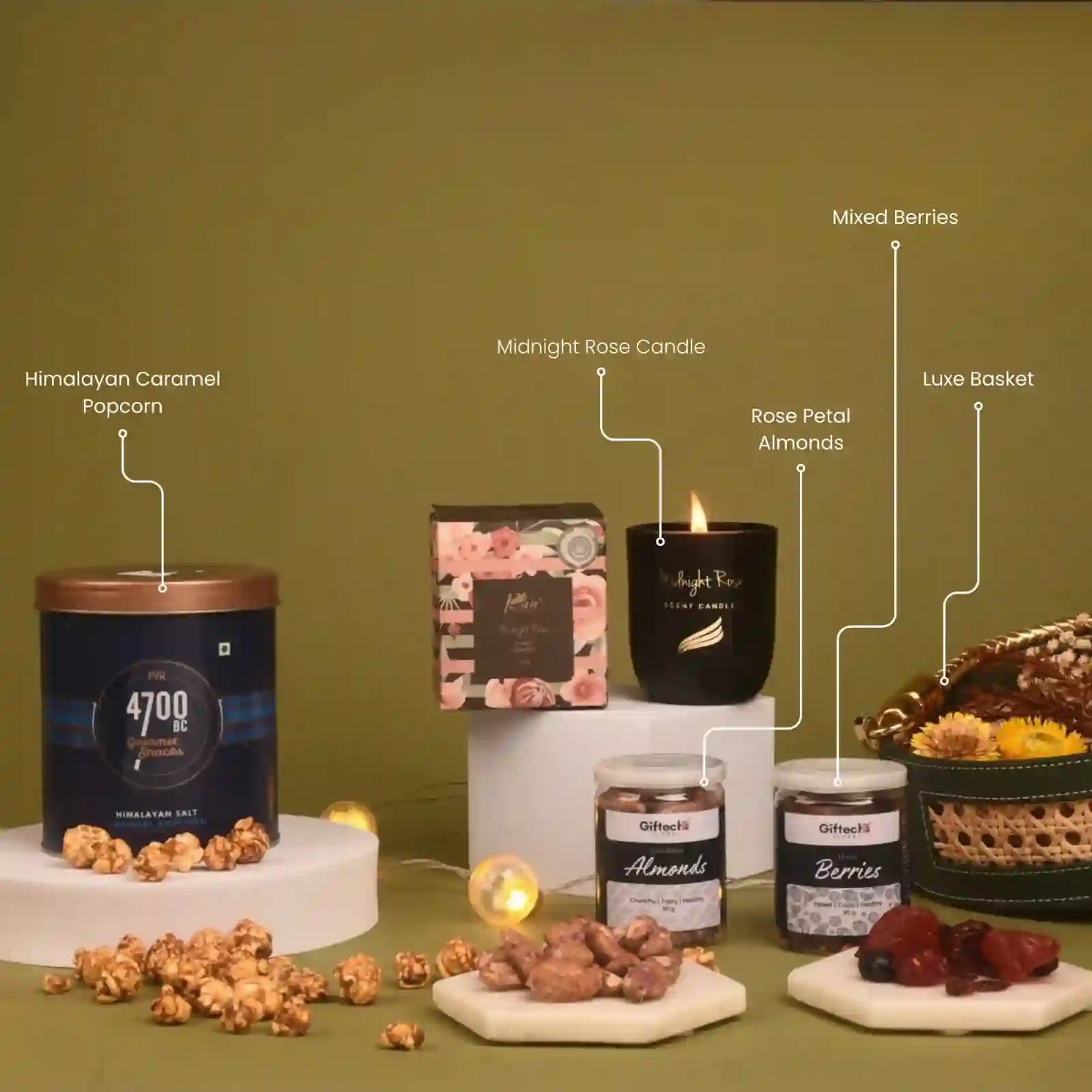 Assorted gourmet products including a candle, popcorn, and jars on a green background