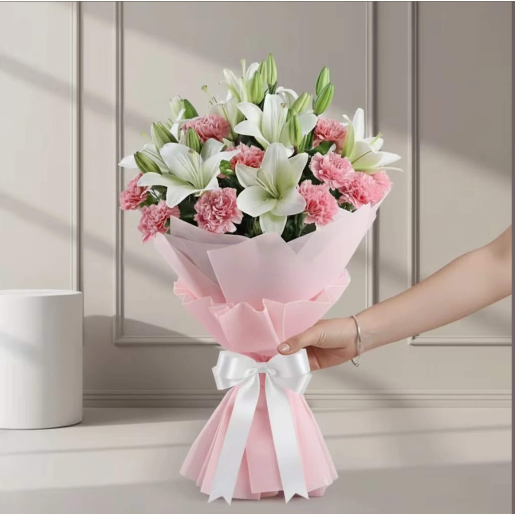 Close-up of white lilies and pink carnations in pink wrapping