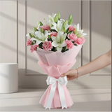 Close-up of white lilies and pink carnations in pink wrapping