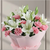 Hand holding a bouquet of white lilies and pink carnations wrapped in pink paper