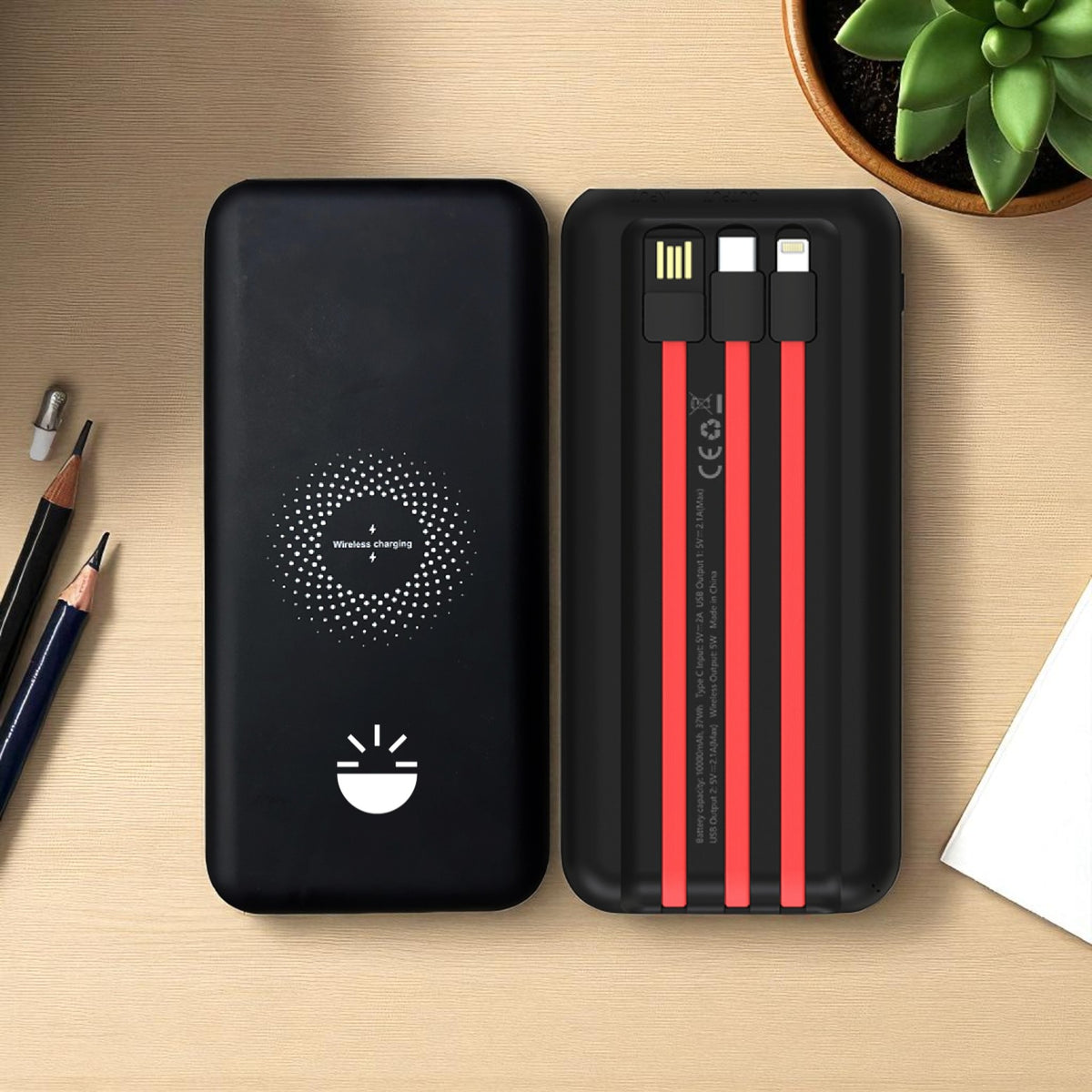 Black power bank with red cable heads on a wooden surface 