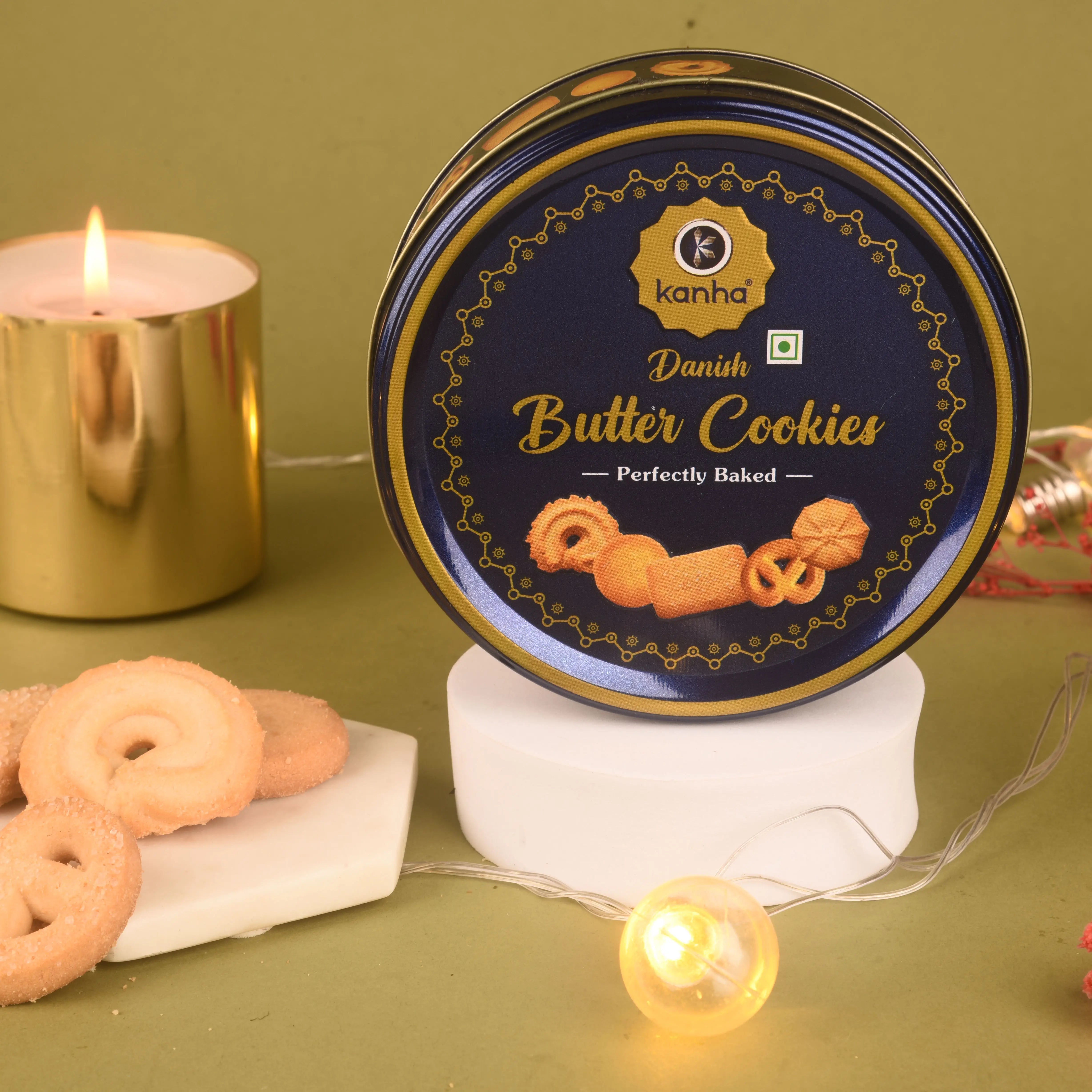 Kanha Danish Butter Cookies tin with cookies and a candle on a green background