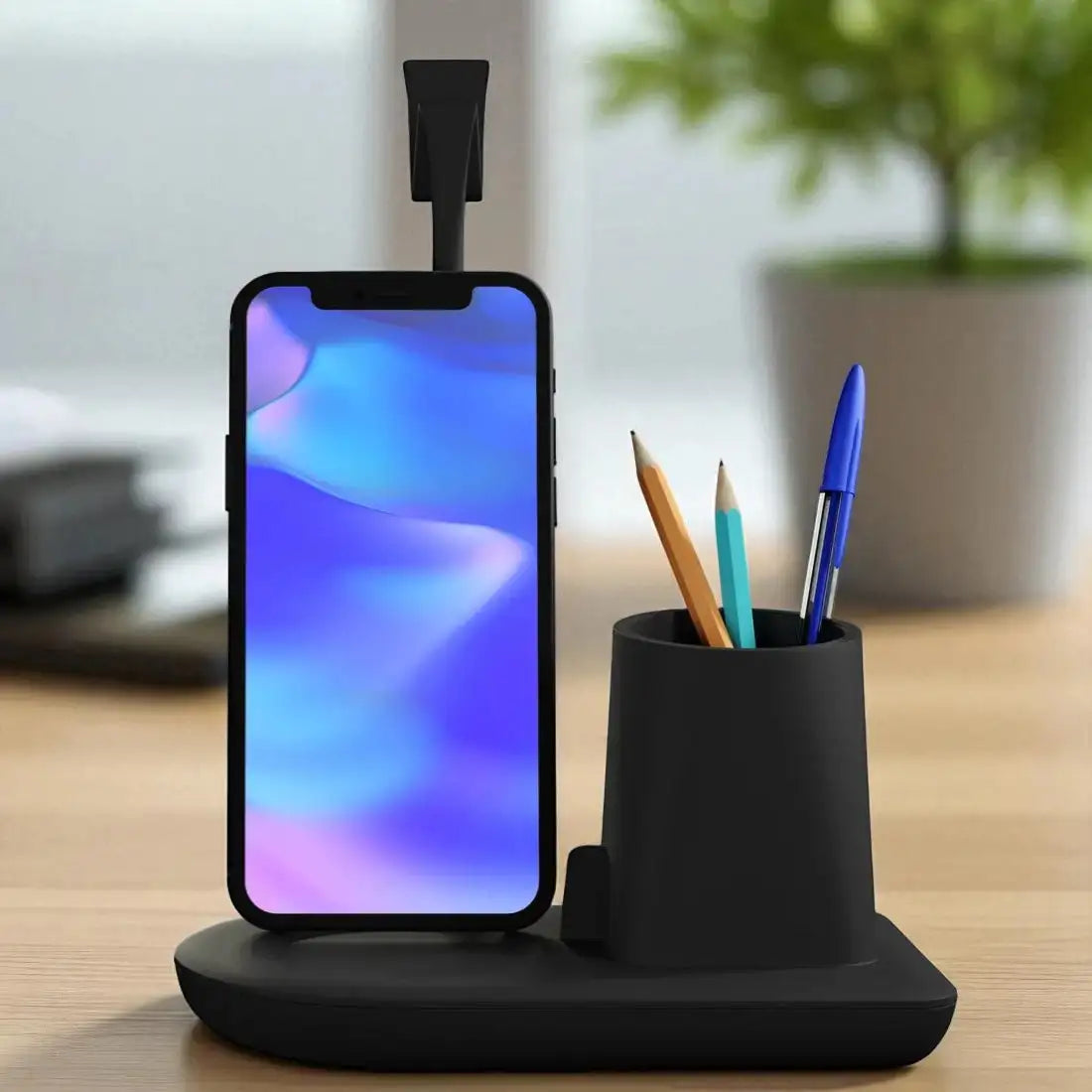 Black phone stand with smartphone displaying a colorful screen, pen holder with pens