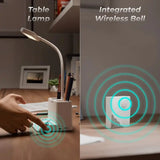 Table lamp with integrated wireless bell on a desk.