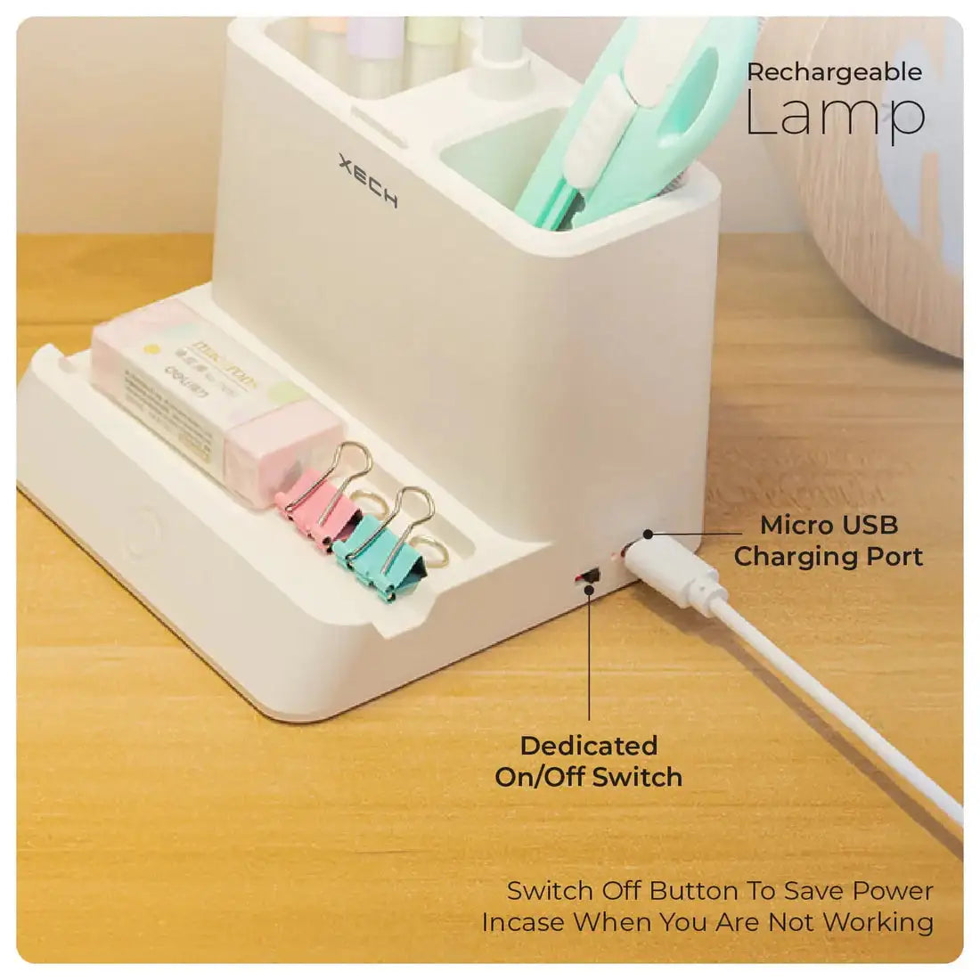 White charging station with USB port, on/off switch, and clips on a wooden surface.