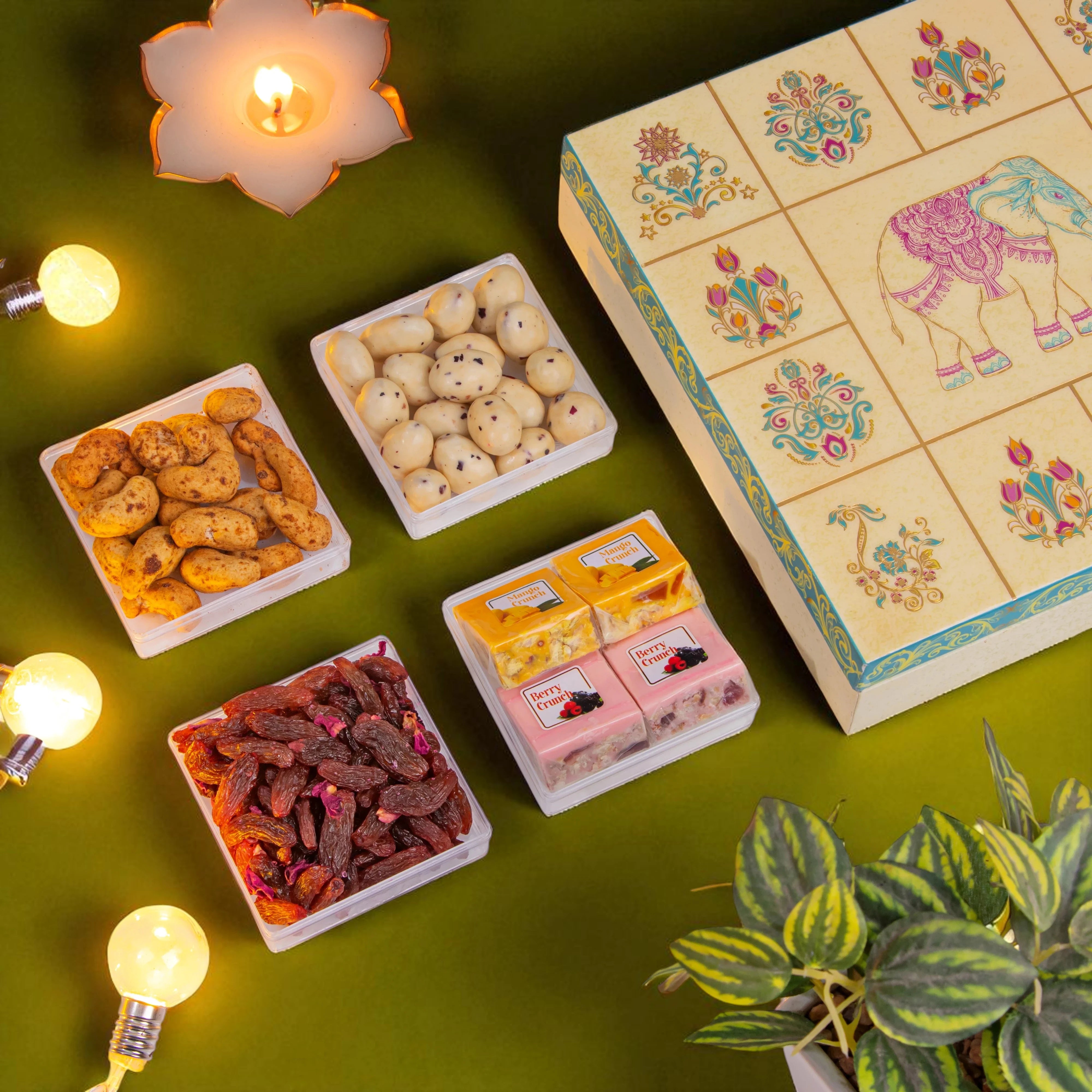 Assorted snacks in small containers with a decorative box on a green surface.