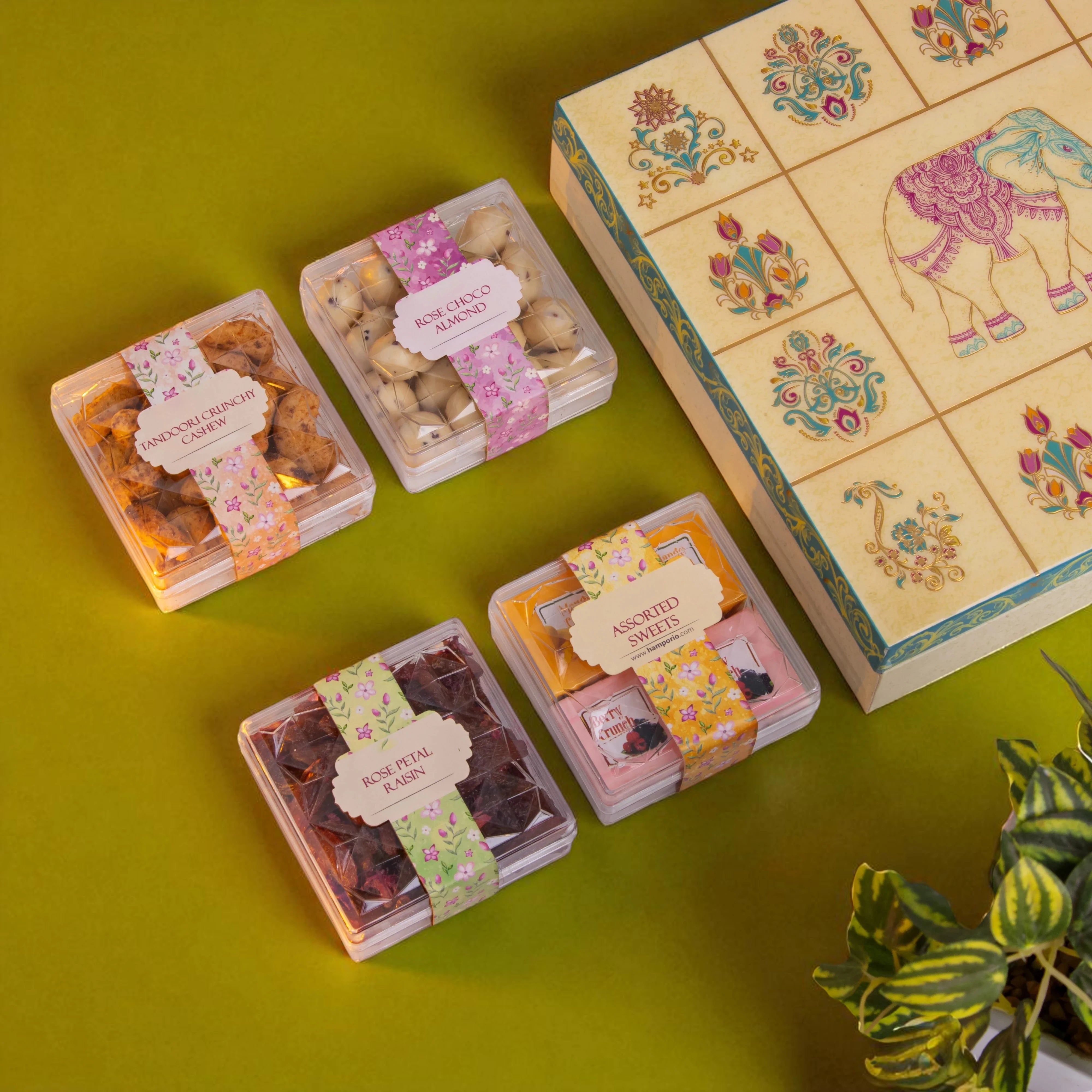 Packaged snacks with decorative boxes on a green surface