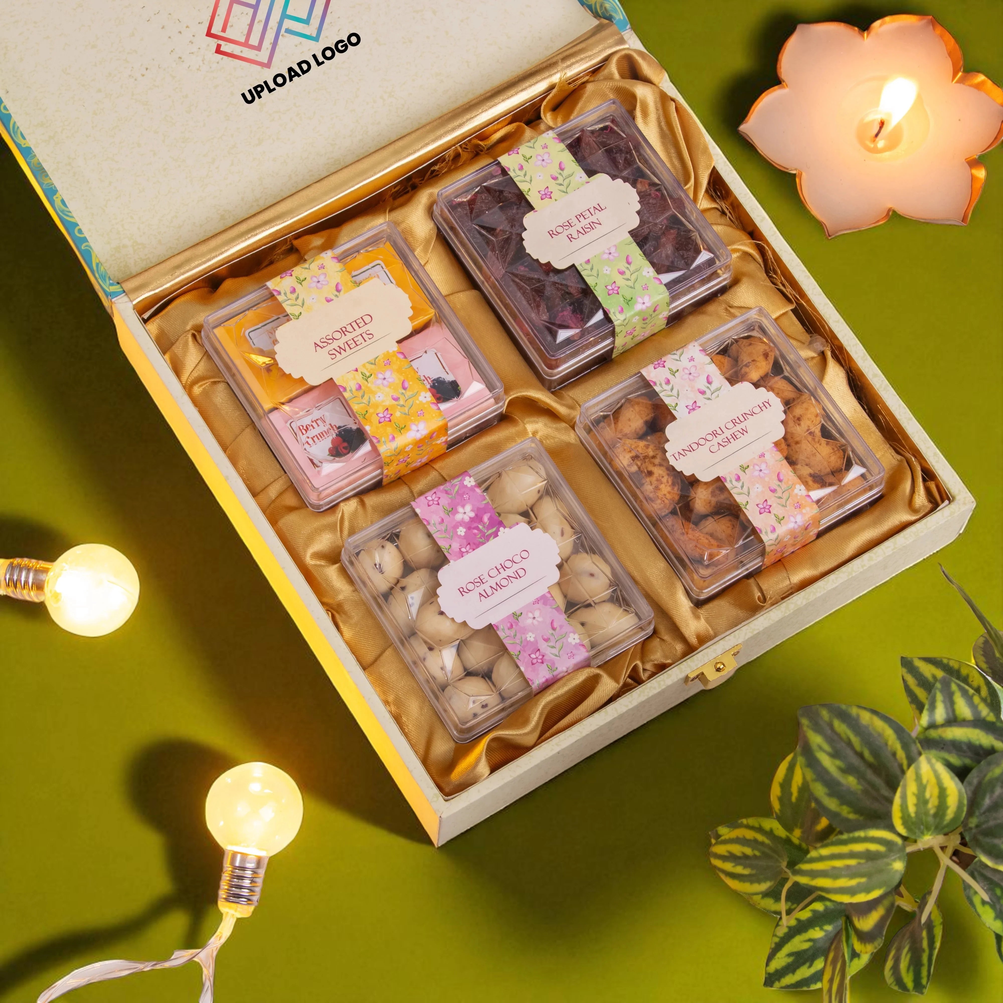 Box of assorted dried fruits with decorative labels on a green background with lights and a plant.