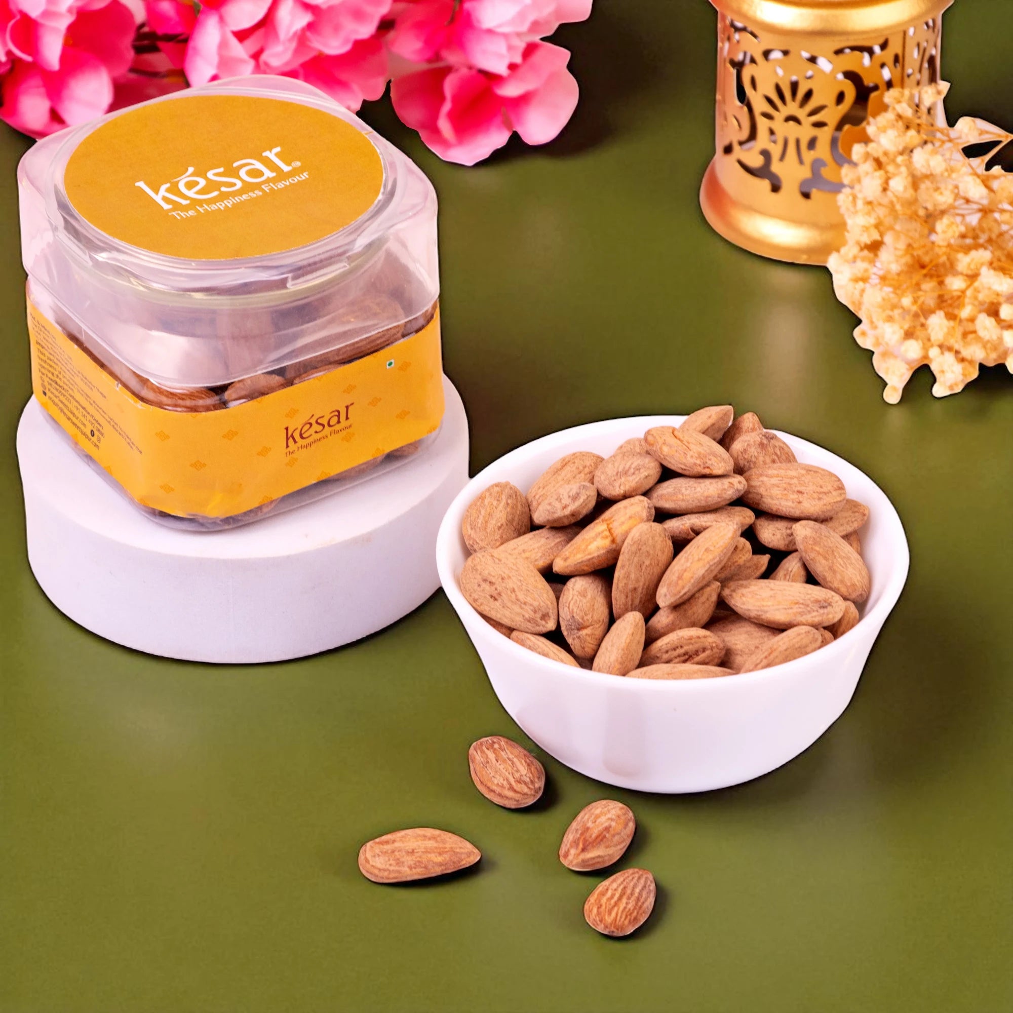 Jar of késar brand product with almonds on a green surface