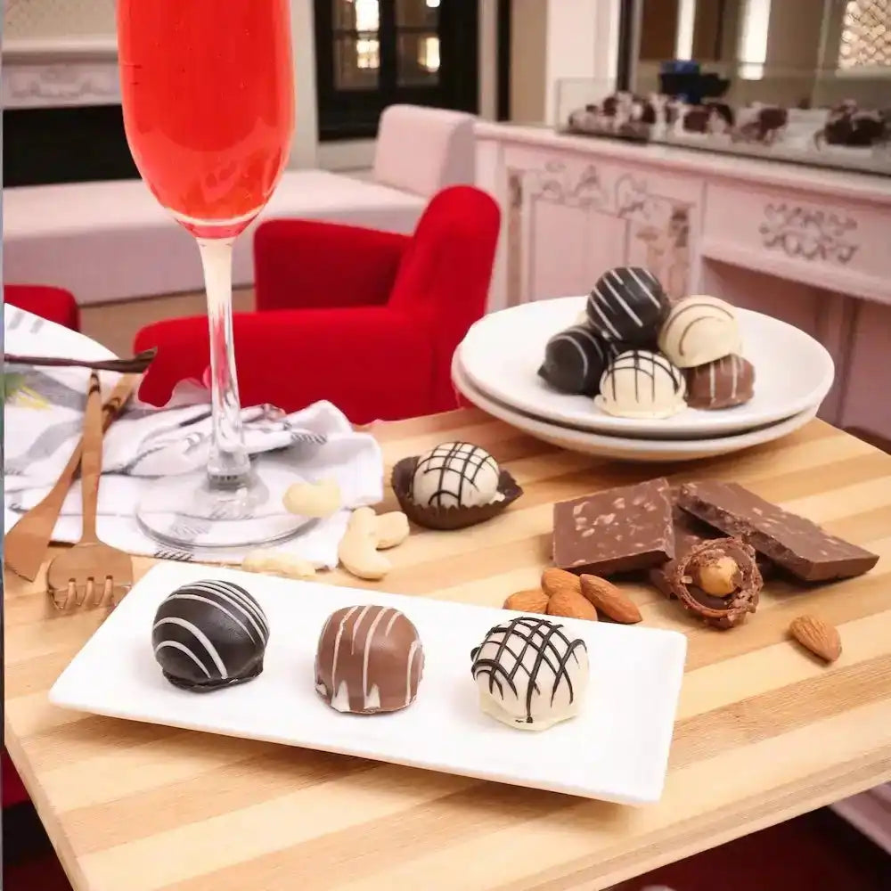 Delight Chocolate Box - Gourmet Gift truffles served with nuts and chocolate bars, paired with a red drink for a festive presentation.