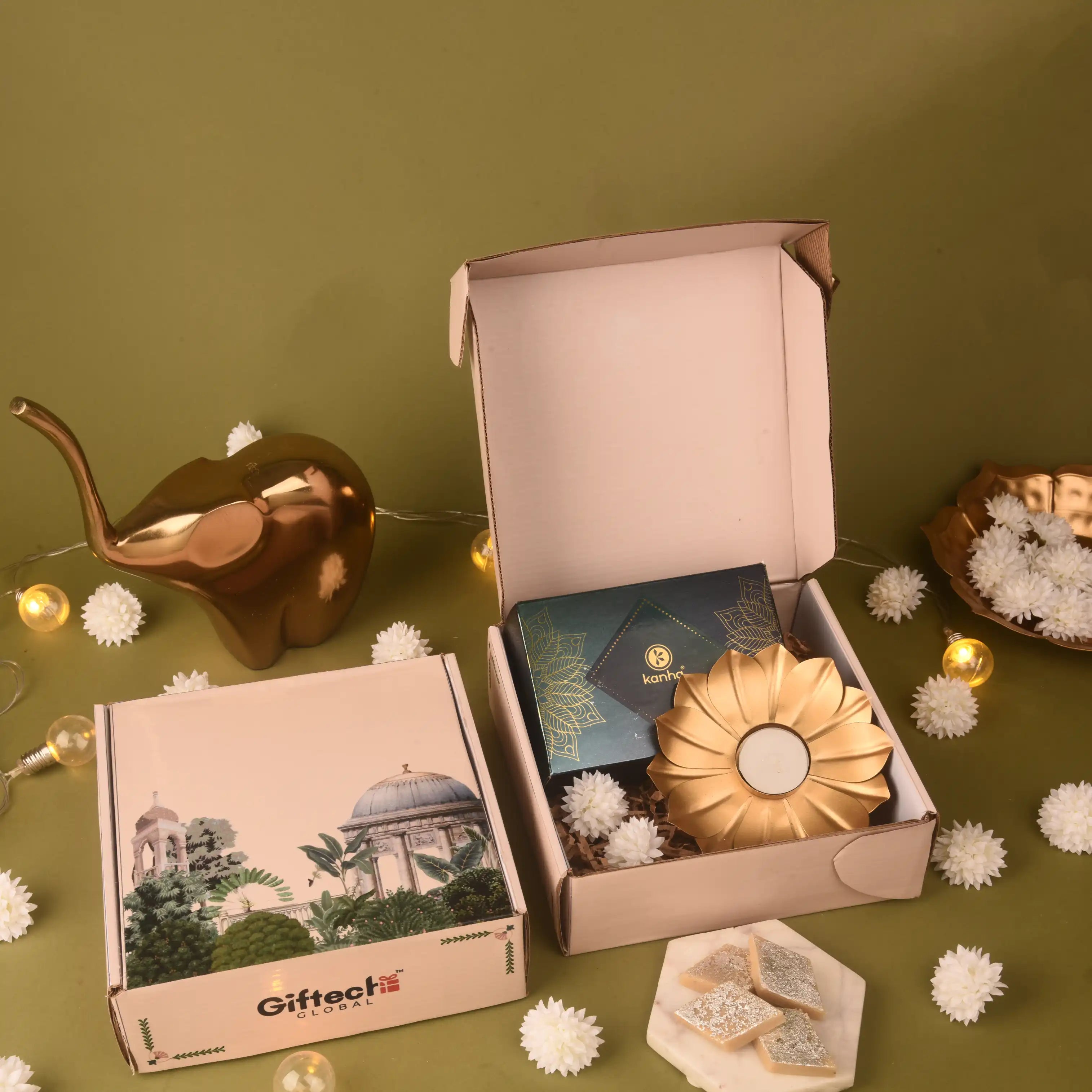 Decorative setup with a box, candles, and a small structure on a green background