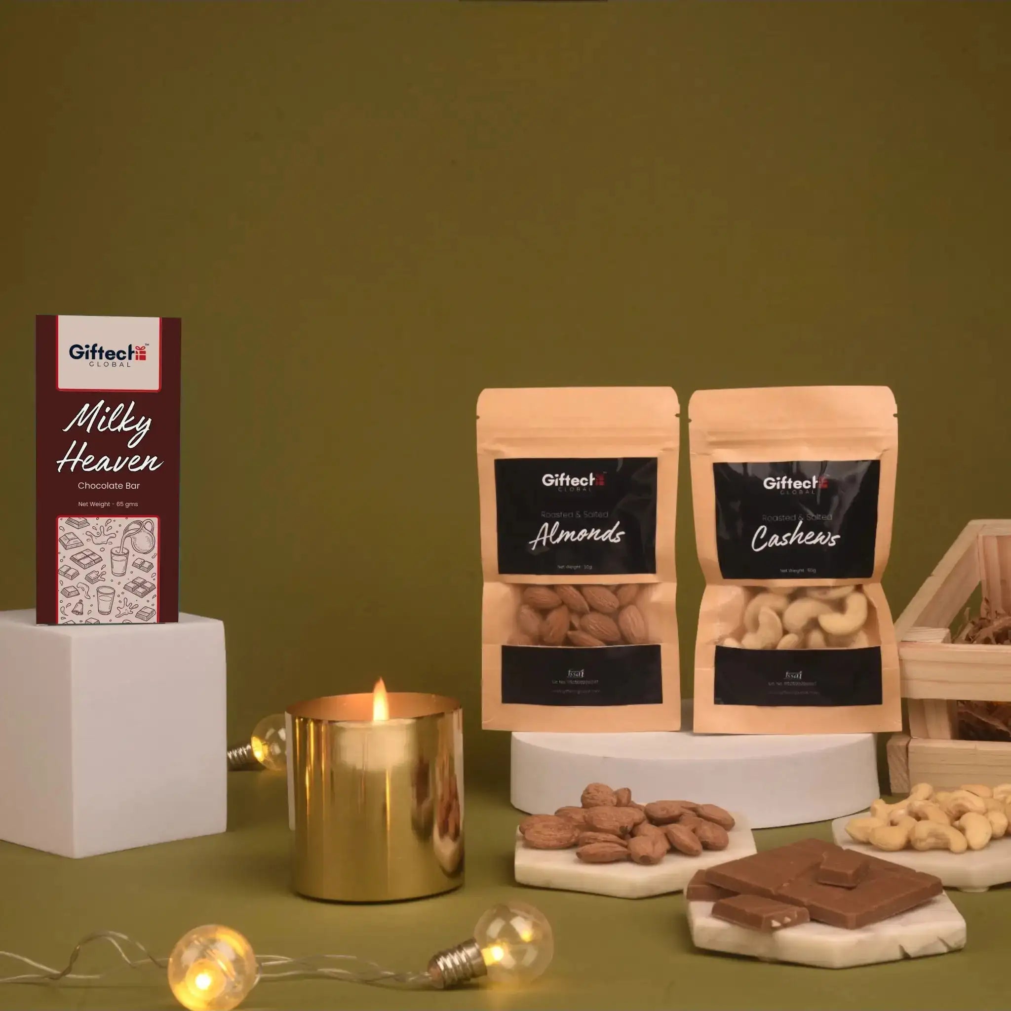 The Nutcracker Treat Box contents displayed: Milky Heaven chocolate bar, almond and cashew pouches, and a gold candle for festive gifting.