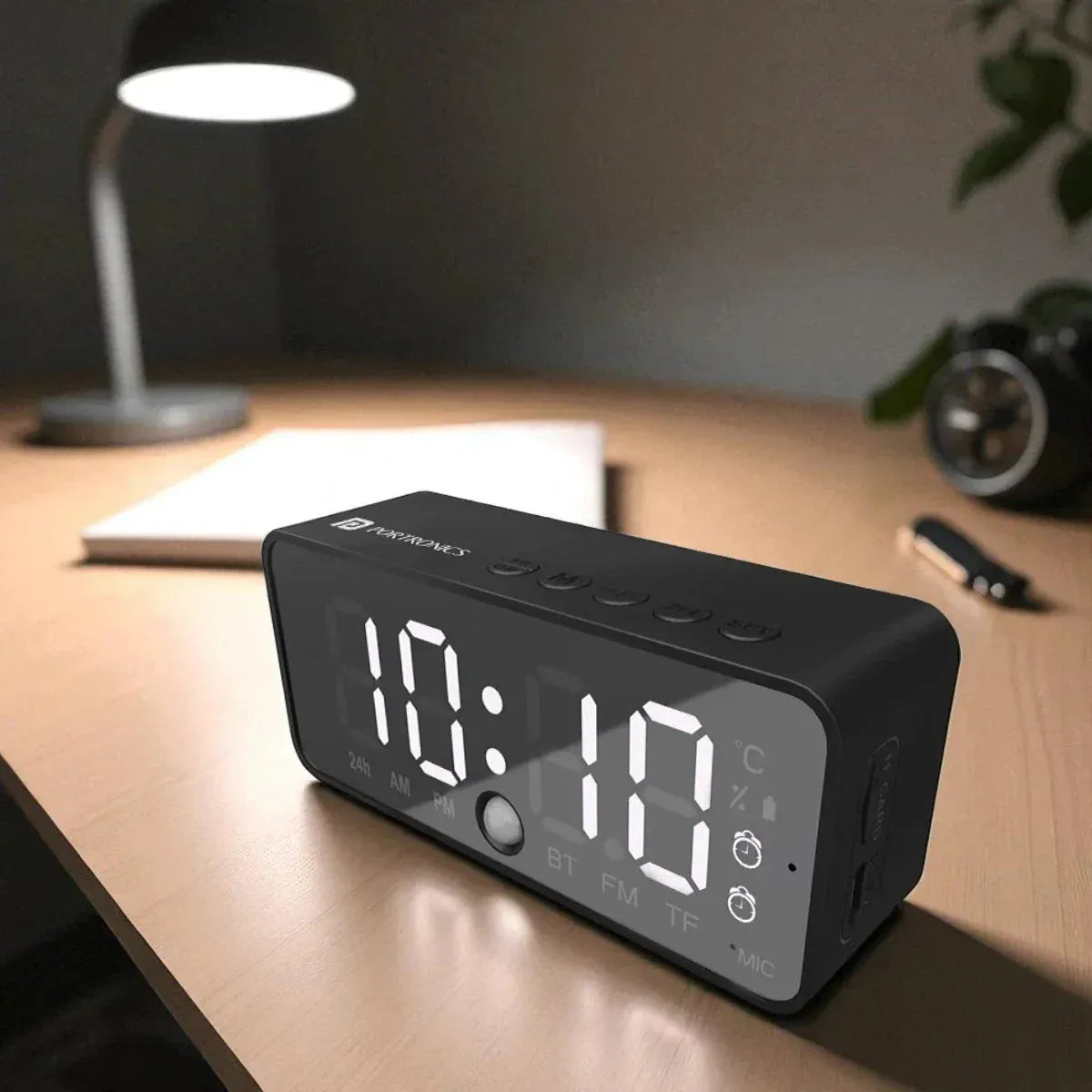 Black digital clock on a wooden desk 