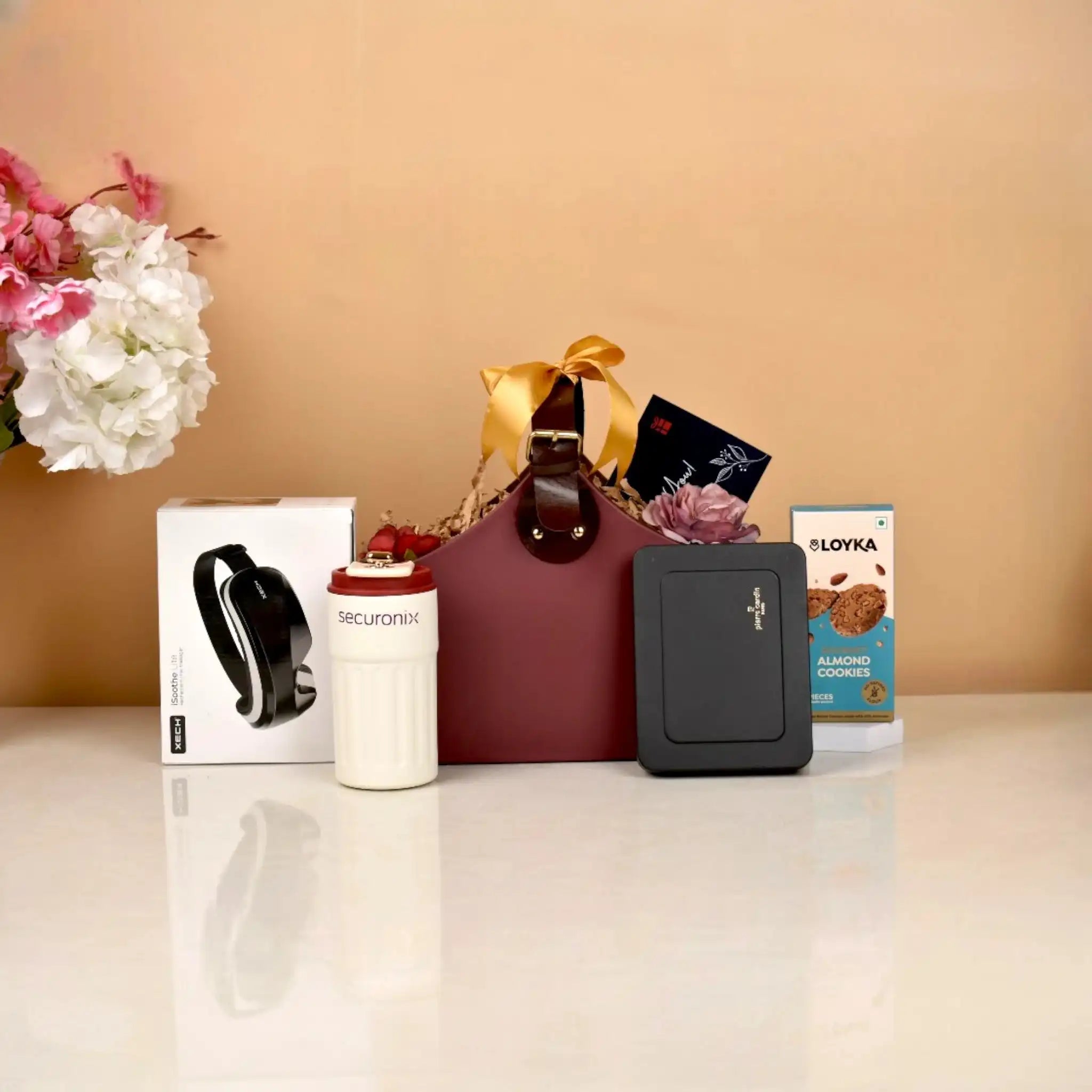 Luxury Elite Indulgence Hamper featuring tech gadgets, gourmet cookies, and premium accessories in a maroon gift tote with yellow ribbon.