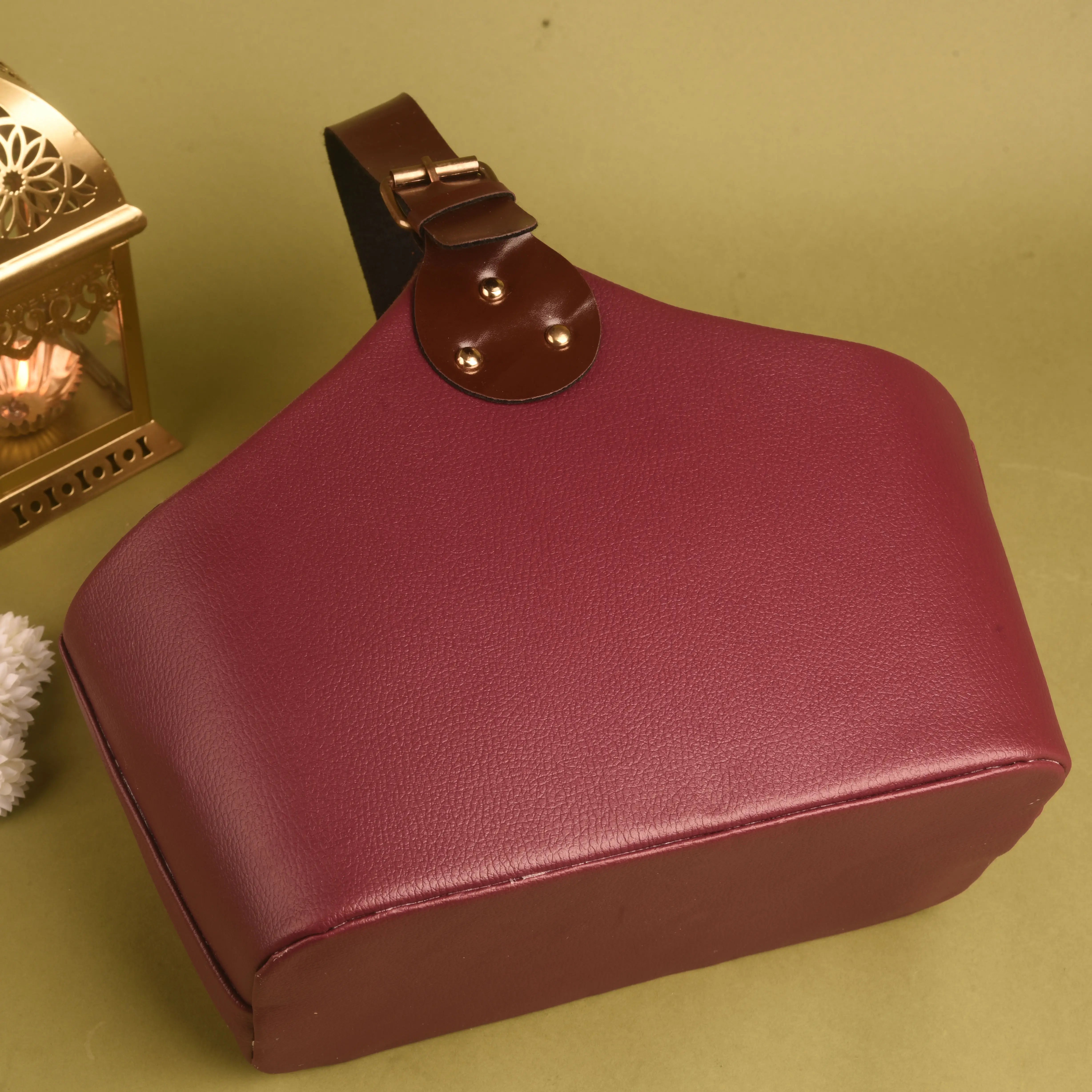 Maroon leather box with a brown handle on a green background