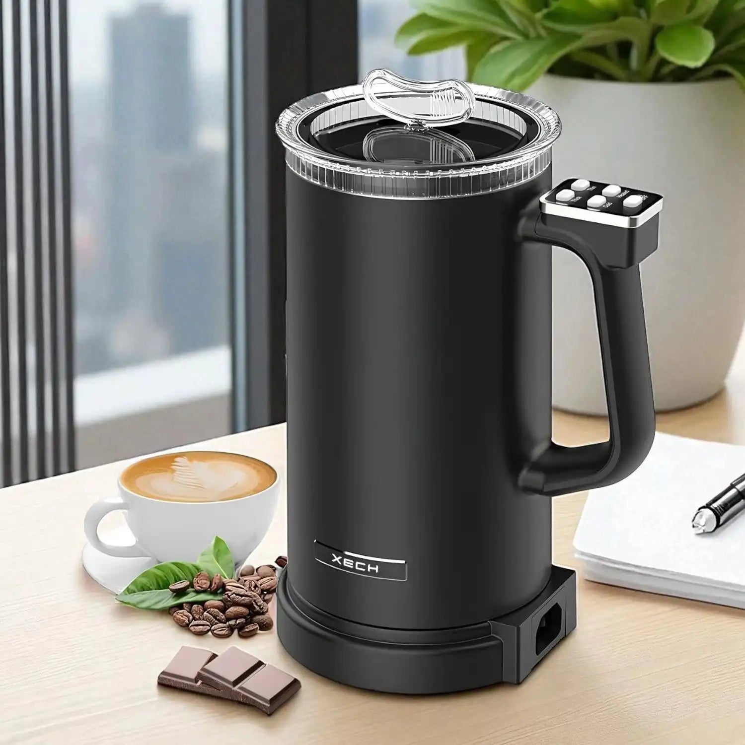 Black electric milk frother on a table with coffee and snacks, featuring the Xtech brand.