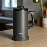 Black XECH coffee press on a wooden surface with a blurred background