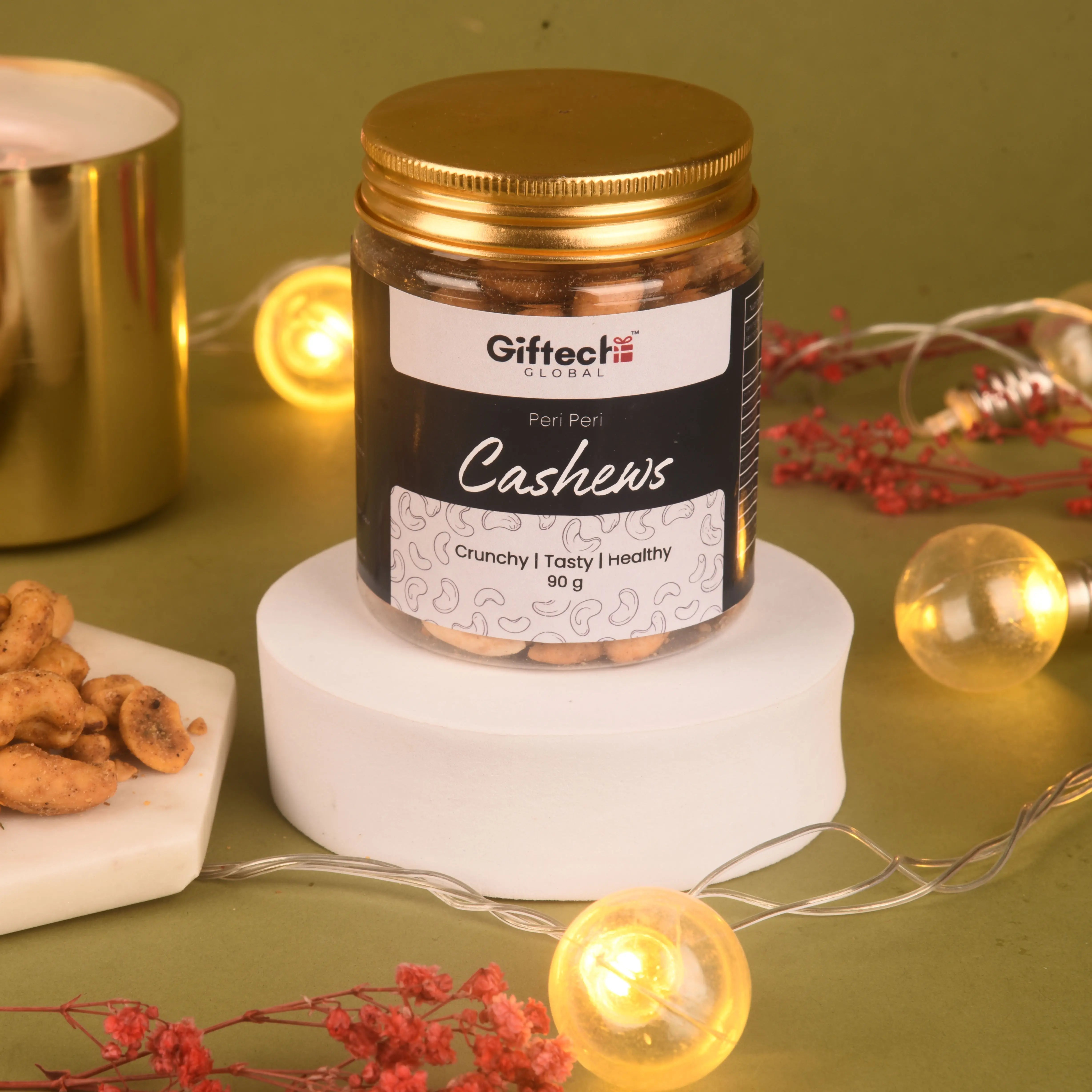 Jar of Giftech Global cashews on a decorative surface with lights and snacks.