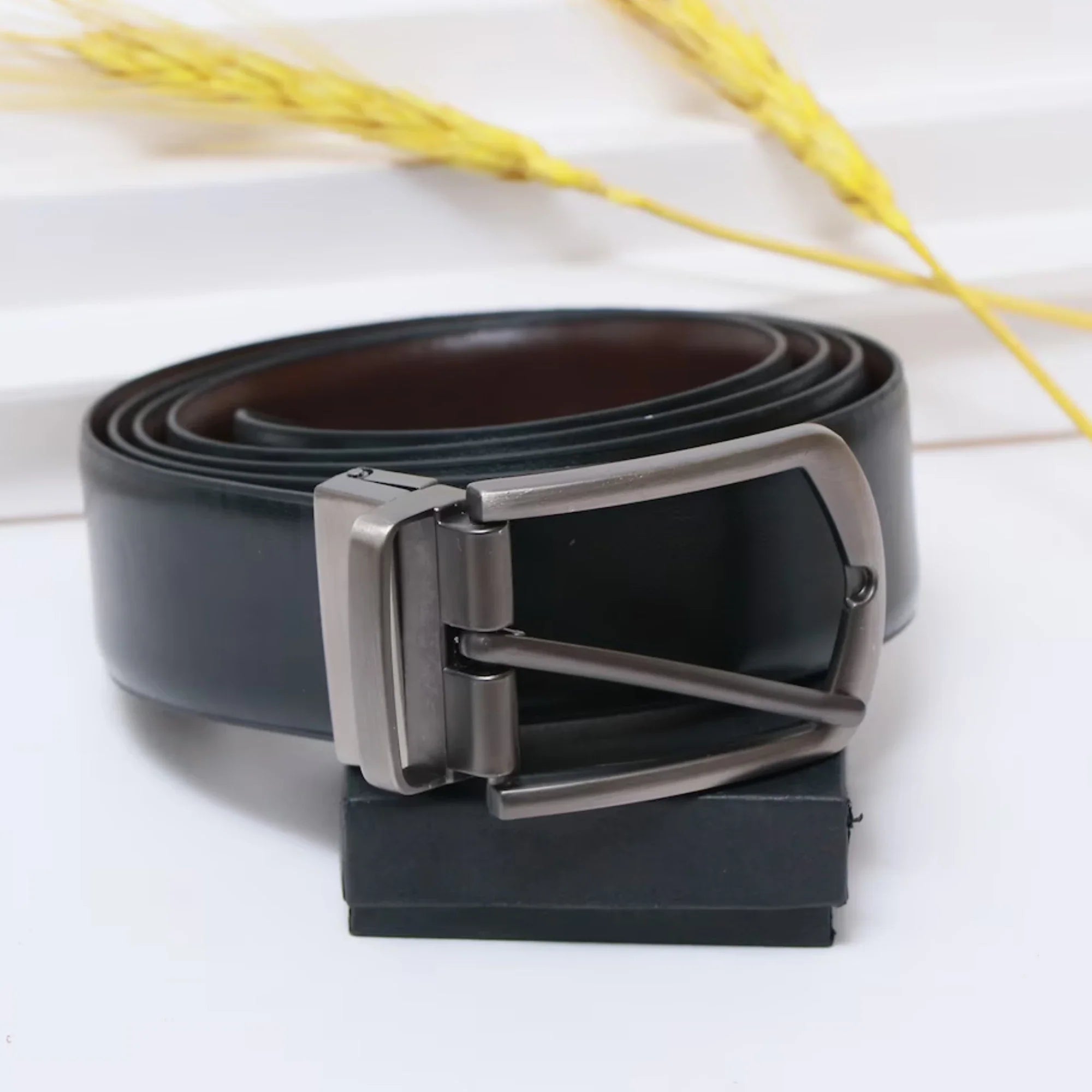 Black leather belt with silver buckle on a white background