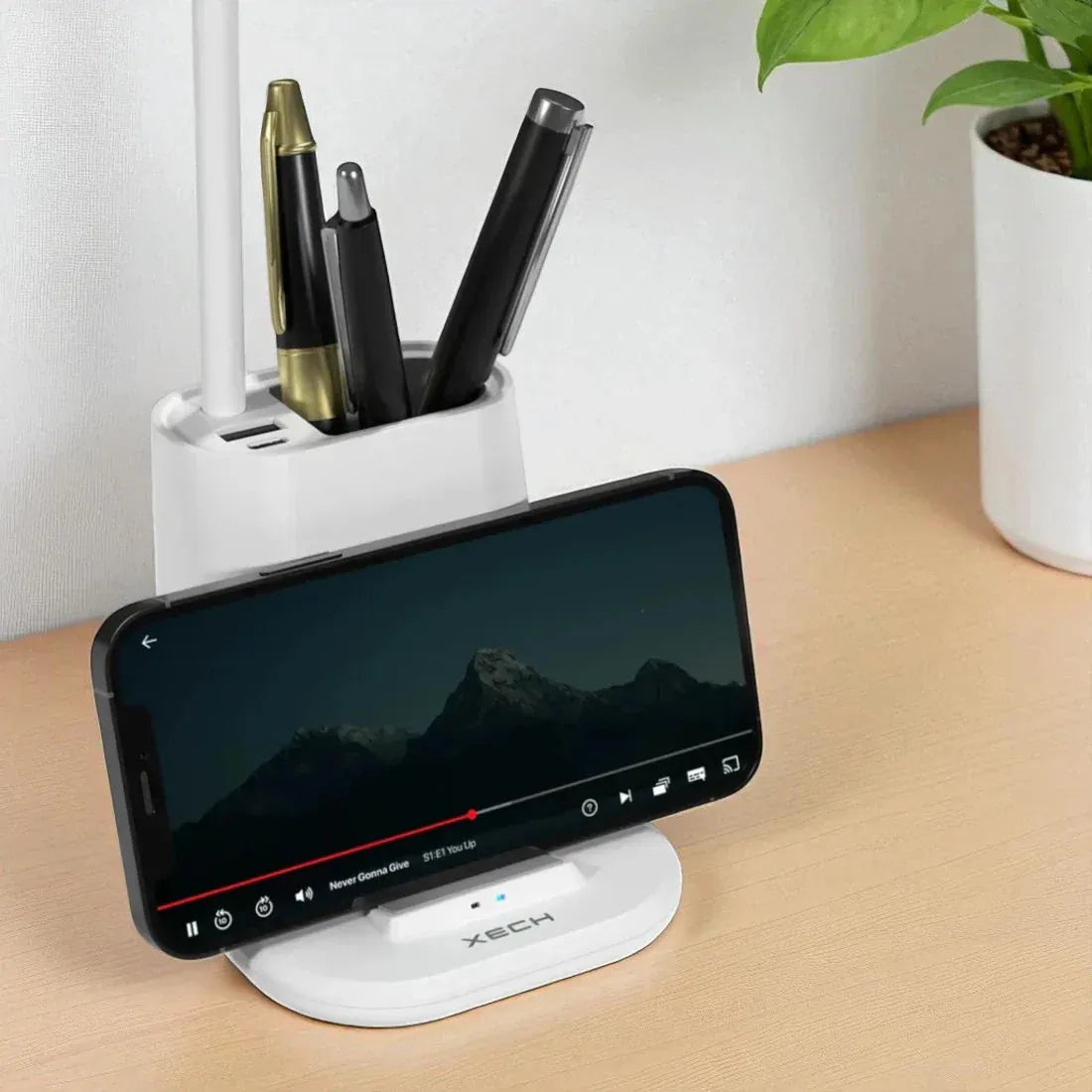 Phone dock with phone and pen holder on a desk