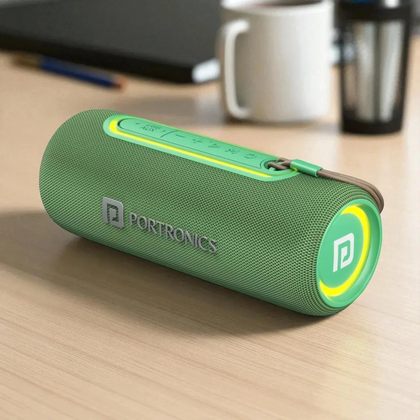 Green Portronics Bluetooth speaker on a wooden surface with a blurred background