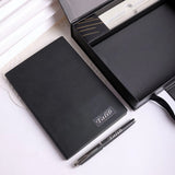 Black notebook and pen set with 'Talib' branding on a white background