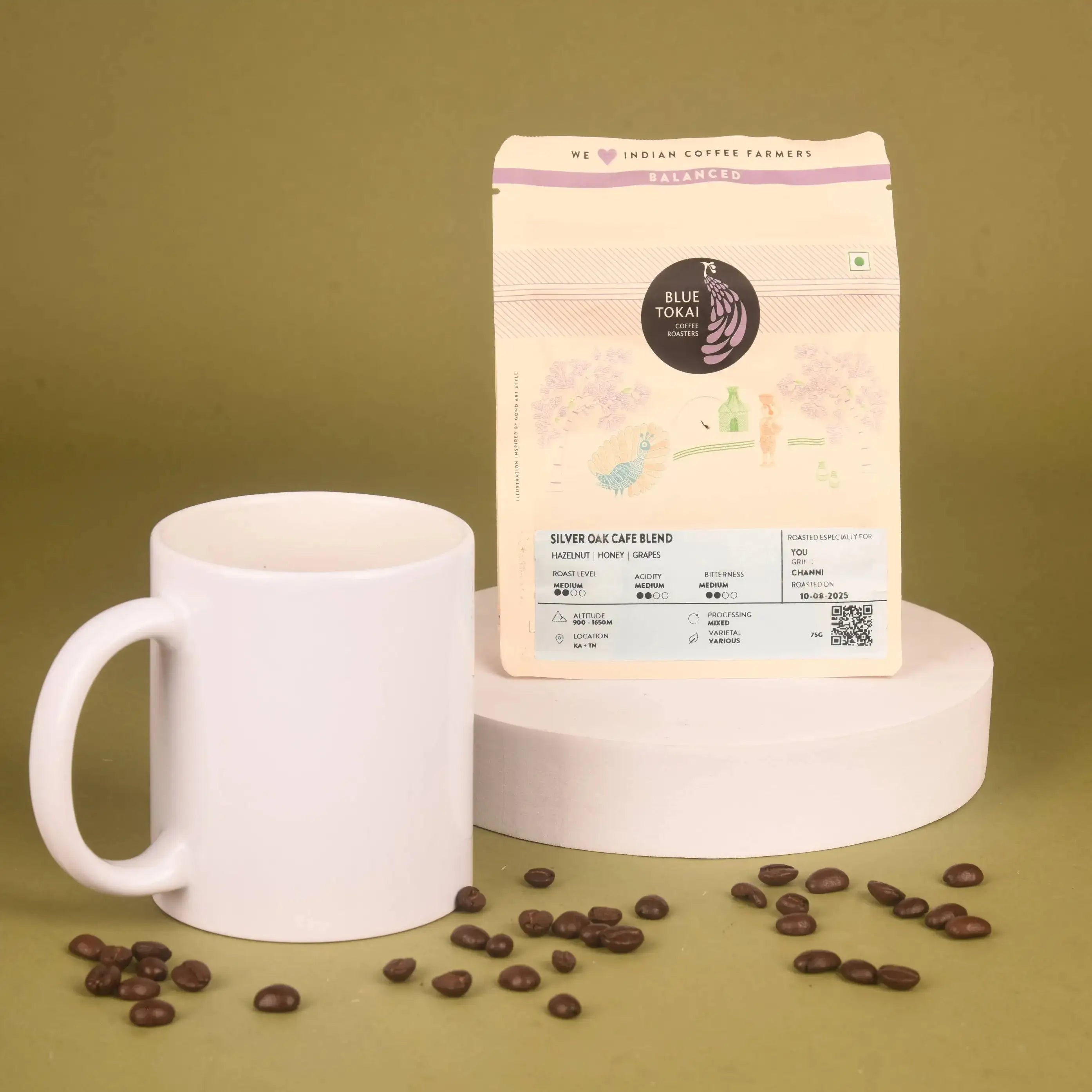 Blue Tokai Silver Oak Café Blend coffee with white mug and beans, featured in The Caffeine Couture Hamper for coffee enthusiasts.