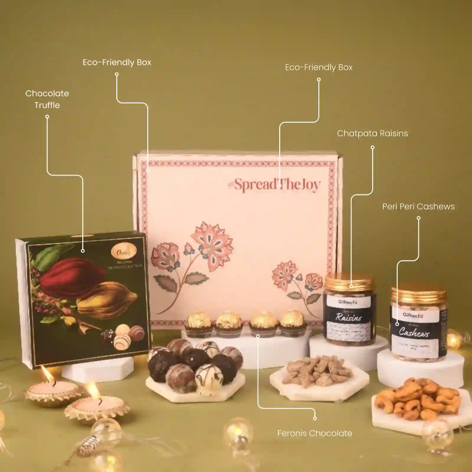 Gourmet gift set with various items including a box of chocolates, truffles, and cashews on a green background.