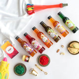 Holi party supplies with Thandai flavor bottles, colorful balloons, powders, and festive decorations