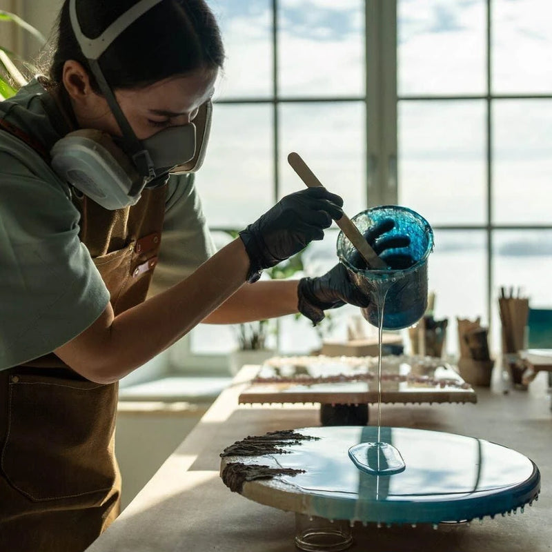 Maker pouring blue resin in a workshop
