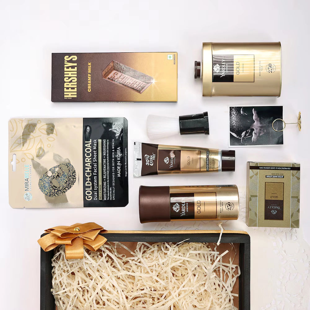 Collection of luxury products including chocolate, skincare items, and a box on a white background