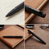 Black pen on a notebook with close-up details on a wooden surface.