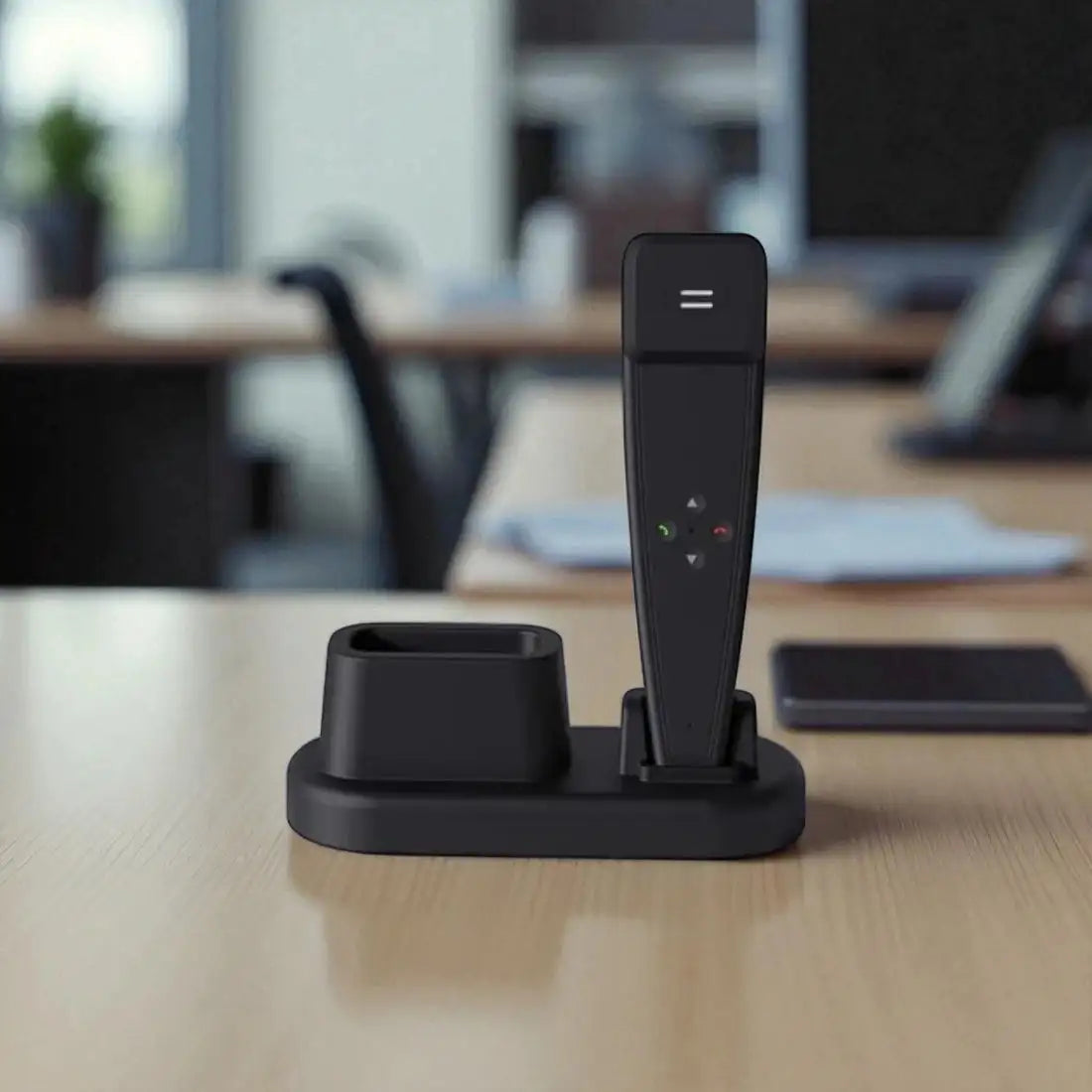 Black desk phone with base on a wooden desk in an office setting